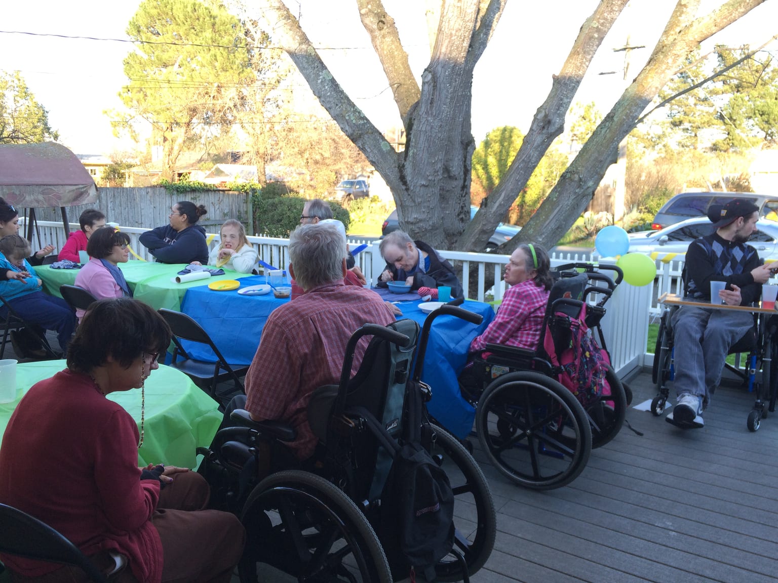 Residents and staff celebrating together on the deck at a DuMolin home.
